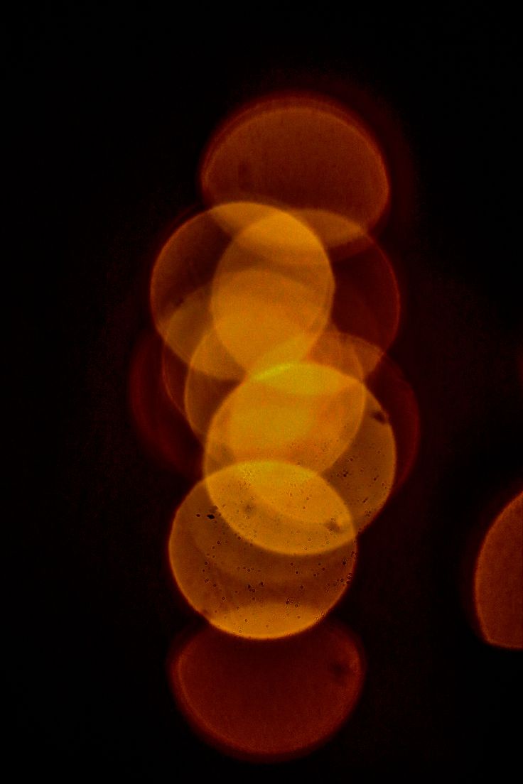 Warm amber and orange bokeh circles glowing out of darkness