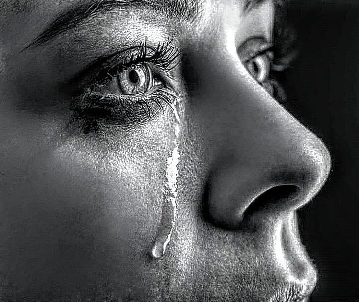 Black-and-white profile of a face with a single tear tracking down the cheek