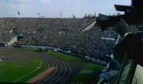 Stadium viewed from broadcast booth, grainy VHS-era colour quality