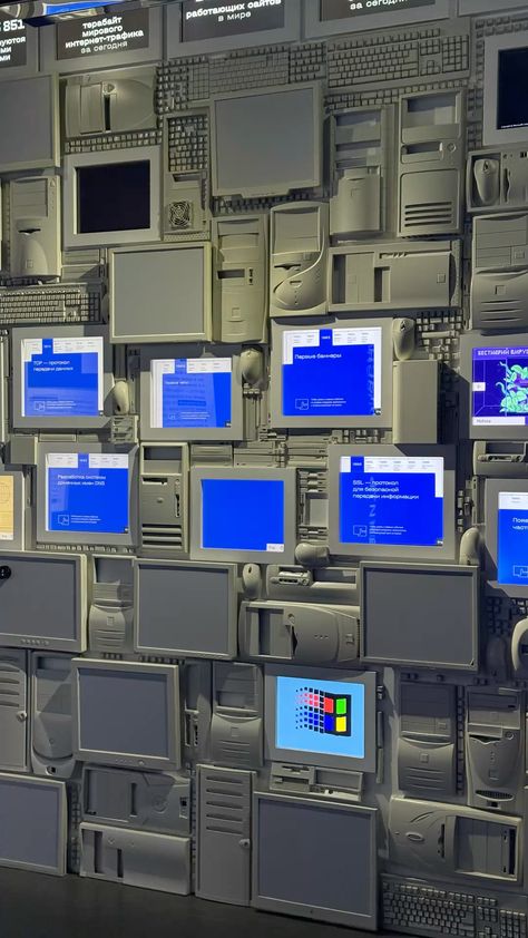 Art installation — wall of vintage computers showing blue Windows screens