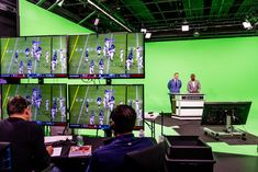 Green screen studio with football on monitors, production crew at desk